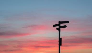 Signpost silhouette against a sunset
